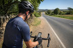 Cyclist checking a route map on a quiet country road at midday
